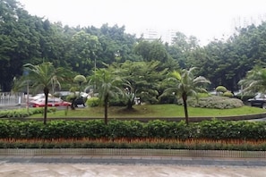 A landscaped area with palm trees, a circular garden, and a low hedge. - Yuebei Hotel (Guangzhou)