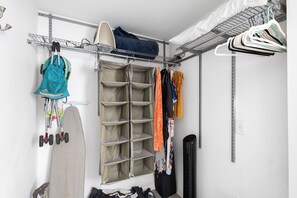 Um armário com prateleiras, cabides e espaço para sapatos.