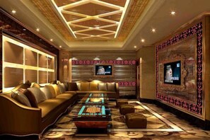 Eine luxuriöse Lounge mit einer Couch, einem Couchtisch und einem Fernsehbildschirm.