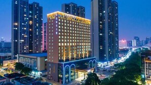 A high-rise hotel with multiple floors, large windows, and a well-lit entrance. - Jiagao Business Hotel(FoShan NanHai WanKe) (Foshan)