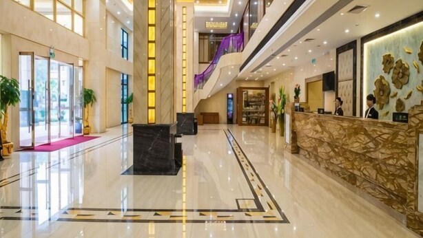 A spacious lobby with a reception desk, a staircase, and a large window. - Jiagao Business Hotel(FoShan NanHai WanKe) (Foshan)
