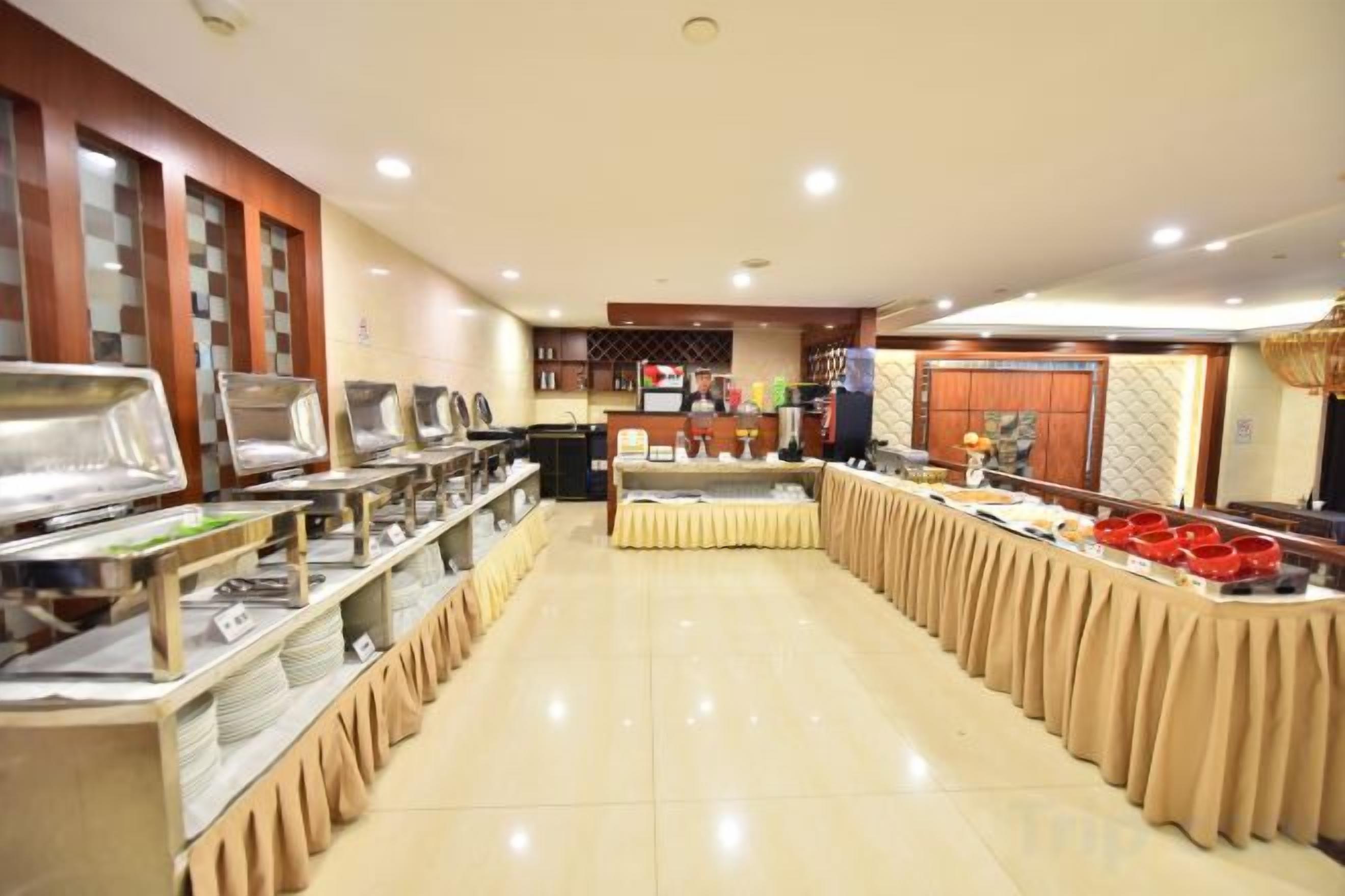 A buffet setup with multiple serving stations and a long table covered with a tablecloth.