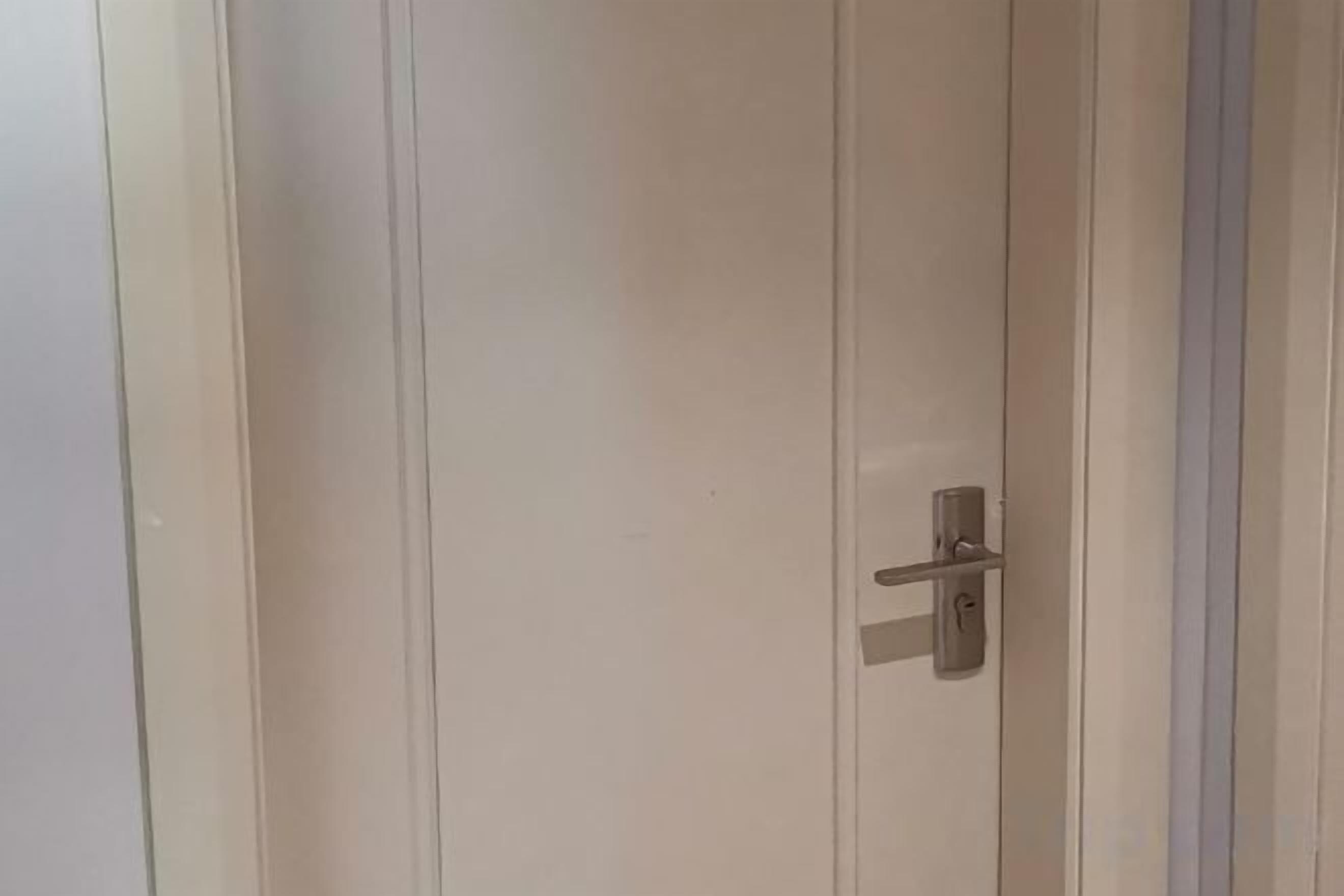 A closed door with a handle and a keyhole.