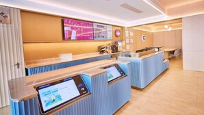 A modern hotel reception area with digital kiosks, a coffee machine, and a seating area. - HanTing Hotel (Zhuhai Jinwan Airport) (Zhuhai)