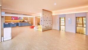 A spacious hotel lobby with a reception desk, seating area, and a decorative partition. - HanTing Hotel (Zhuhai Jinwan Airport) (Zhuhai)