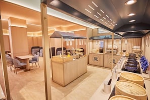 A modern interior with a central counter, seating area, and a buffet setup. - HanTing Hotel (Zhuhai Jinwan Airport) (Zhuhai)