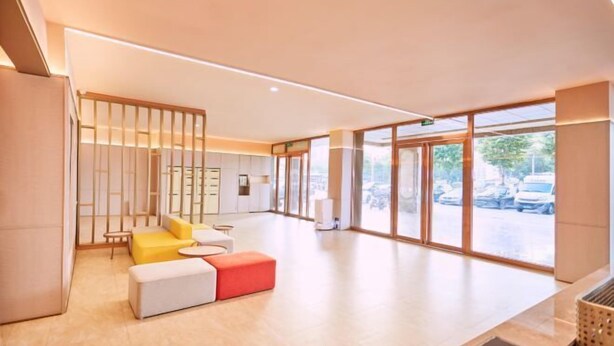 A modern hotel lobby with a seating area, large windows, and a reception desk. - HanTing Hotel (Zhuhai Jinwan Airport) (Zhuhai)