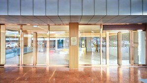 A modern hotel entrance with glass doors, a polished marble floor, and a wooden panel accent. - HanTing Hotel (Zhuhai Jinwan Airport) (Zhuhai)