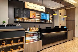 Interior d'una cafeteria amb mostrador, tauler de menús i exposició de begudes.