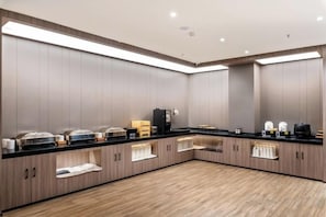 Cuina moderna amb electrodomèstics integrats, una barra llarga i armaris d'emmagatzematge.