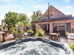 A brick house with a patio, a hot tub, and a garden. - 5 bedroom accommodation in Ashbourne (Ashbourne)