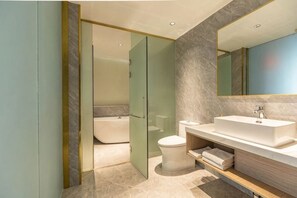 Un baño moderno con cabina de ducha de vidrio, un lavamanos blanco y un espejo grande.