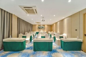 A conference room with a long table, chairs, and a projector screen. - Oukai Hotel (Hangzhou)