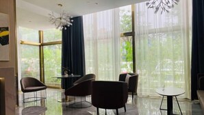 A modern interior with a glass floor, large windows, and contemporary furniture. - Oukai Hotel (Hangzhou)