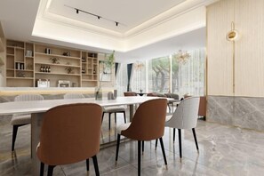 A modern dining area with a marble floor, a long table, and contemporary chairs. - Oukai Hotel (Hangzhou)