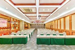 A conference room with rows of tables, green tablecloths, and white chairs. - Oukai Hotel (Hangzhou)