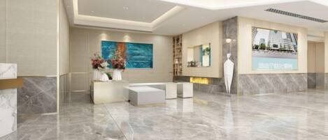 A modern hotel lobby with a marble reception desk, a seating area, and a large digital display.