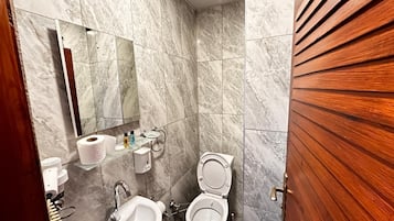 Quarto clássico, sacada, vista parcial para o mar | Banheiro | Chuveiro, produtos de toalete grátis, secador de cabelo