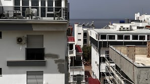 Um edifício com várias andares e varandas com vista para a água.