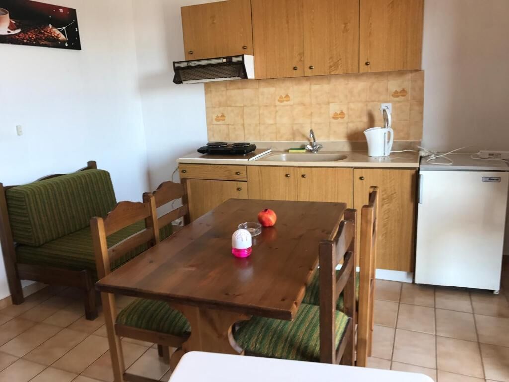 A compact kitchen with wooden cabinets, a sink, and a small refrigerator.