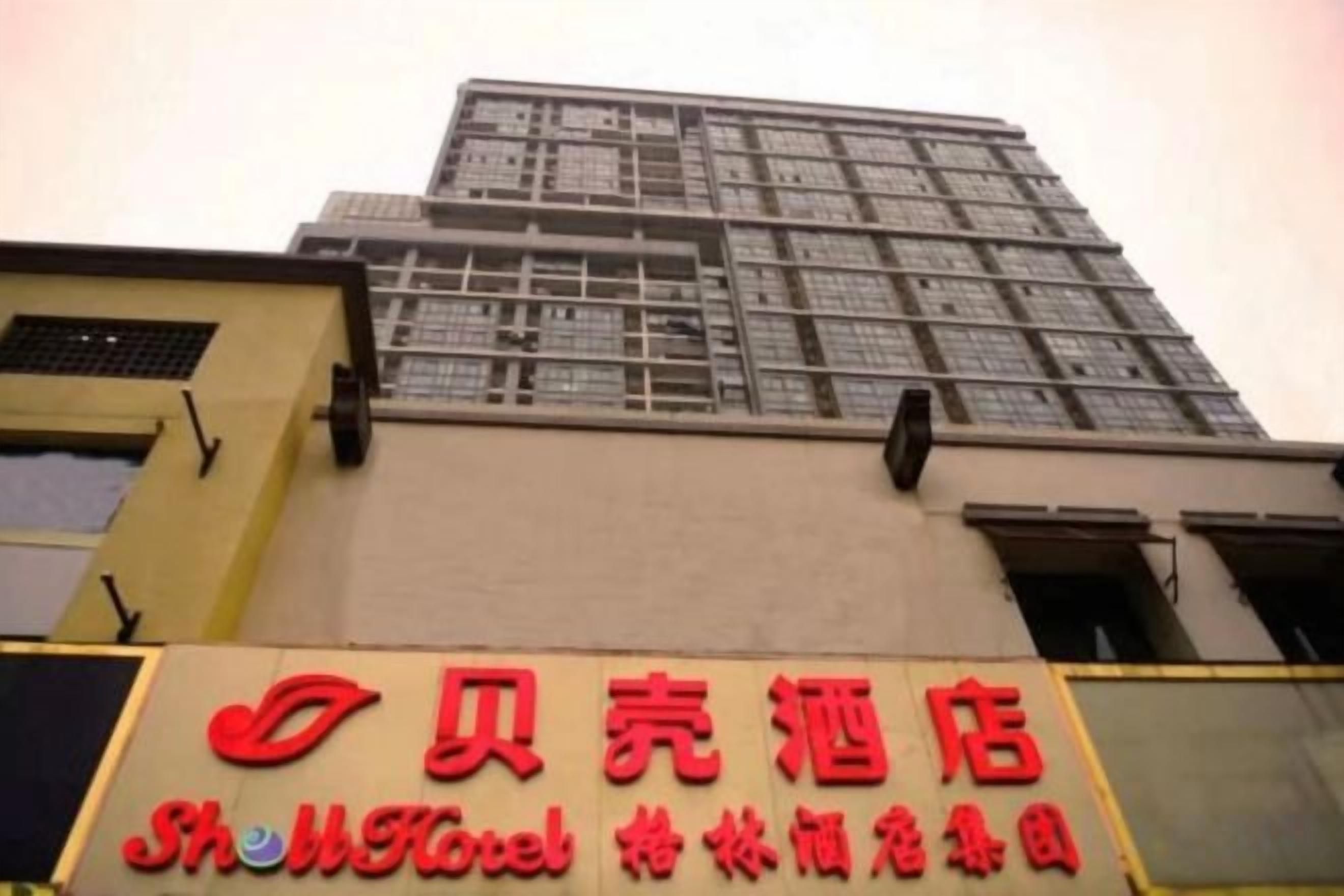A hotel sign with the name 'Shenli Hotel' and a red logo.