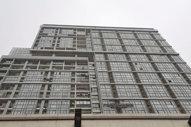 A high-rise building with a grid of windows and a central entrance.