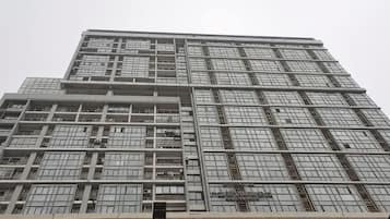 Un edificio de gran altura con una fachada de ventanas enrejada y una entrada central.