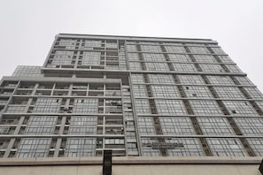 Un edificio de gran altura con una fachada de ventanas enrejada y una entrada central.