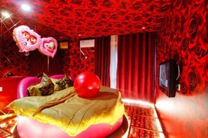 A room with a bed, a television, and a red patterned wall. - Shell Hotel (Hefei Maanshan Road Hegongda Subway Station) (Hefei)