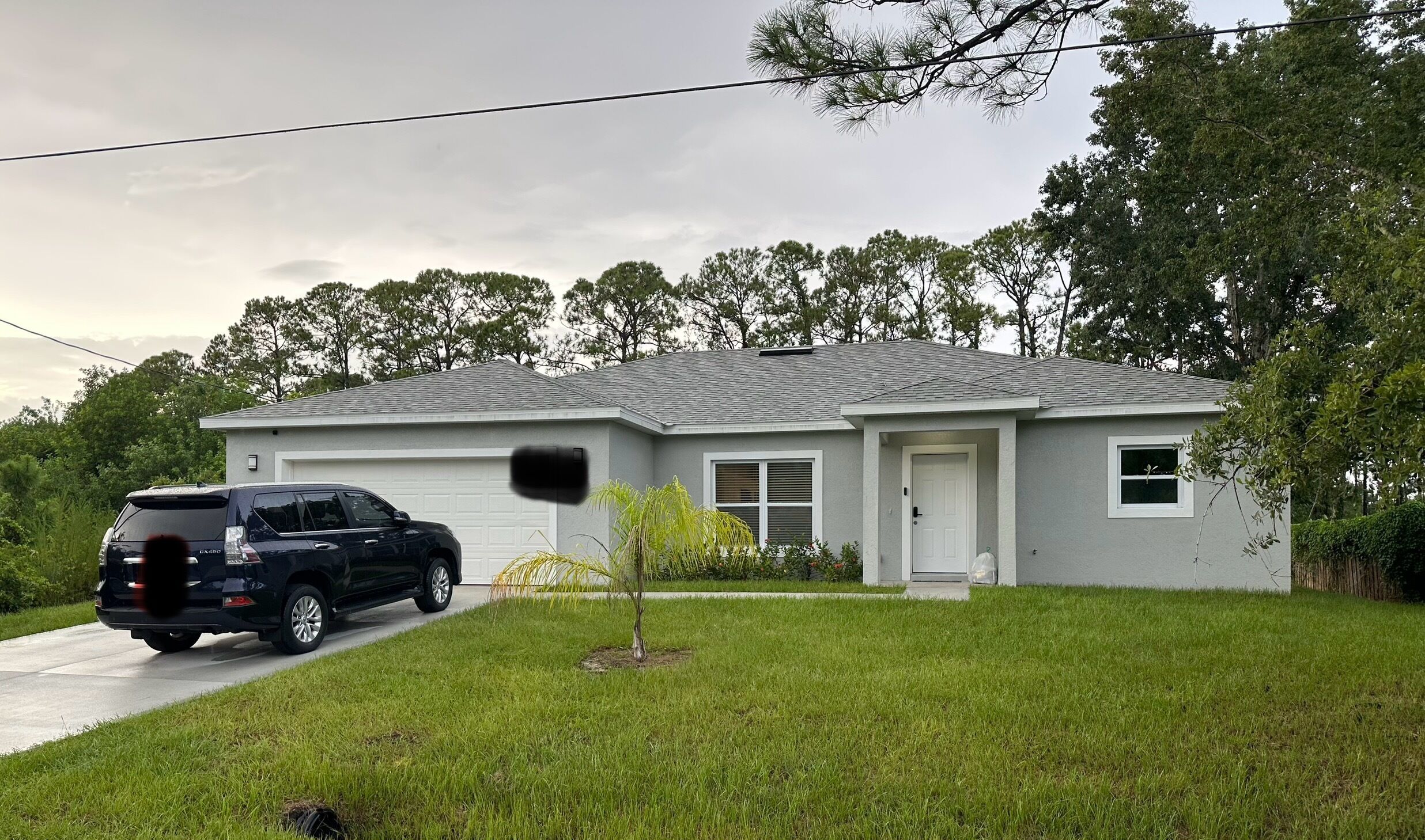 A residential house with a garage, a driveway, and a lawn.