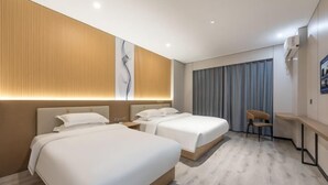 A hotel room with two beds, a desk, a chair, and a large window with curtains. - Shunjie Hotel (Yuyao)