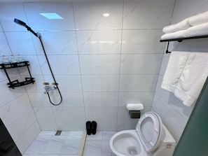 Features a shower, toilet, and towel rack with two towels.
