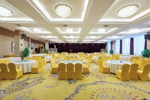 A banquet hall with round tables and yellow chairs, a patterned carpet, and a high ceiling with recessed lighting. - Jinyang Hotel (Exhibition Center Store)） (Guiyang)