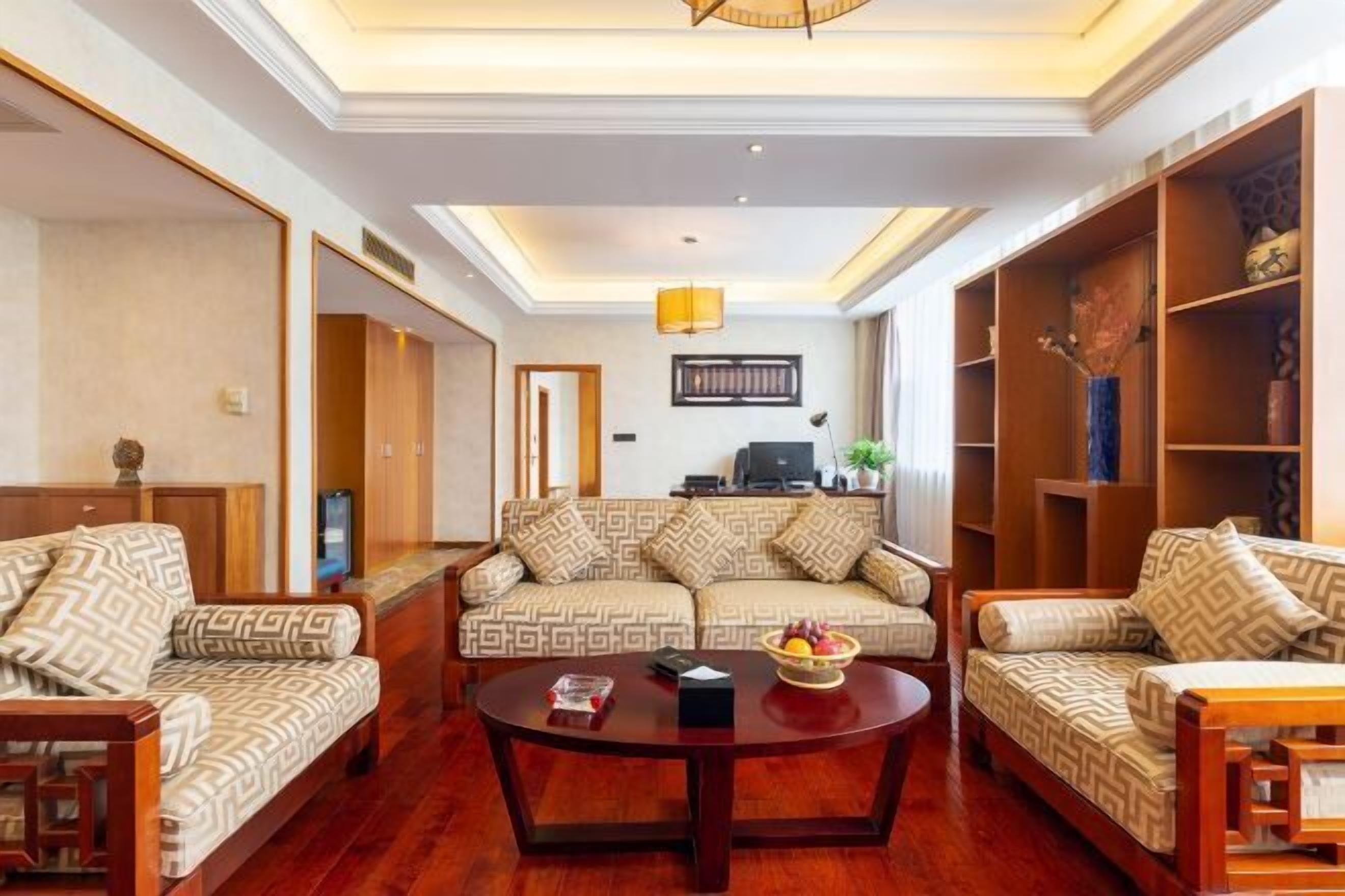 Uma sala de estar com um sofá, uma mesa de centro e estantes embutidas com objetos decorativos.