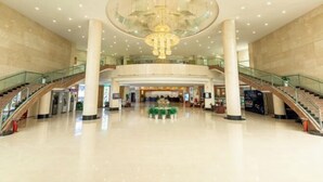 A spacious lobby with a large chandelier, multiple staircases, and a central seating area. - Jinyang Hotel (Exhibition Center Store)） (Guiyang)