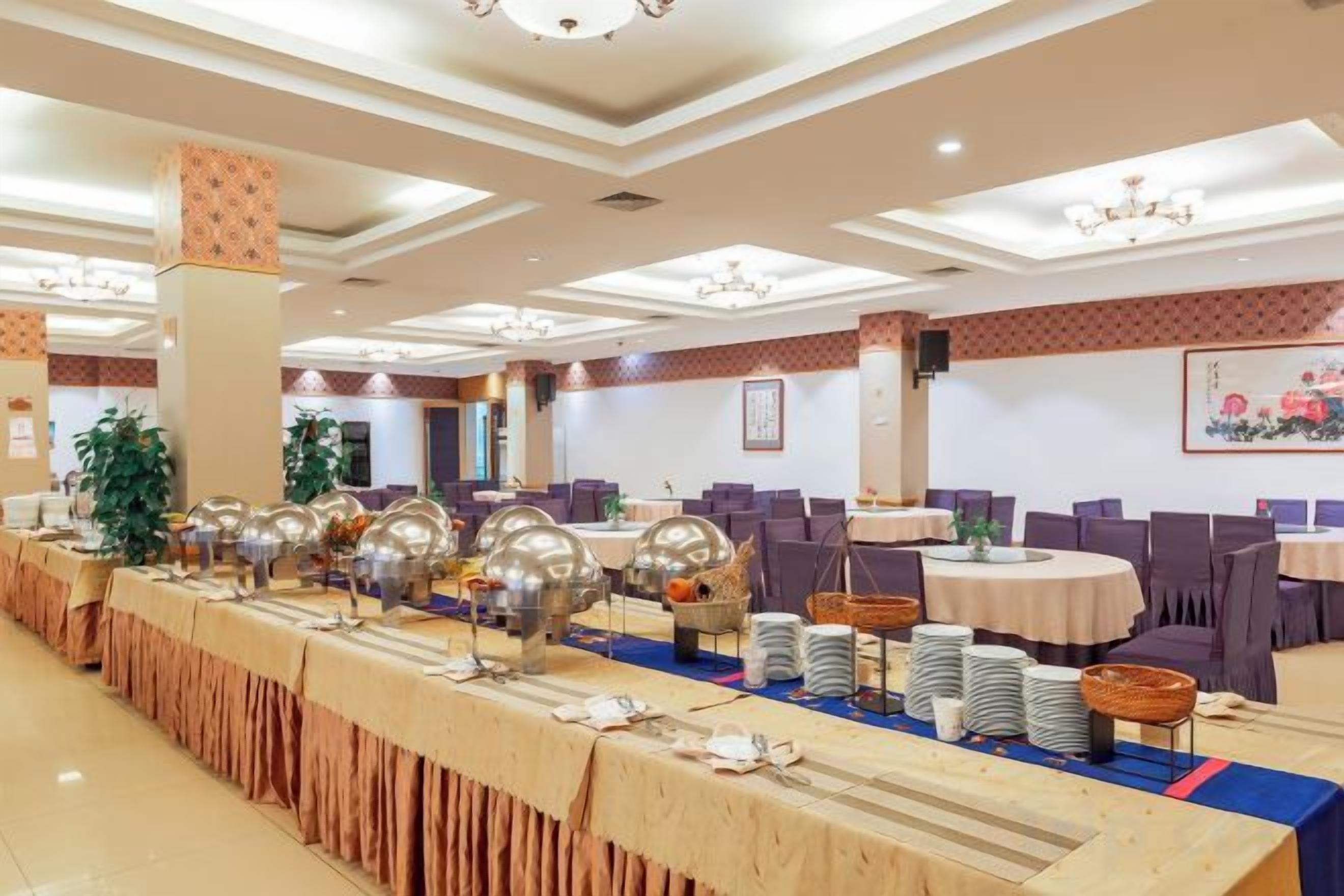 A banquet hall with round tables, chairs, and buffet stations.