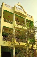 A multi-story building with balconies, decorative railings, and a central archway.
