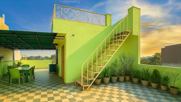 A rooftop terrace with a checkered floor, a staircase, and potted plants. - Anukampa Guest House (Agra)