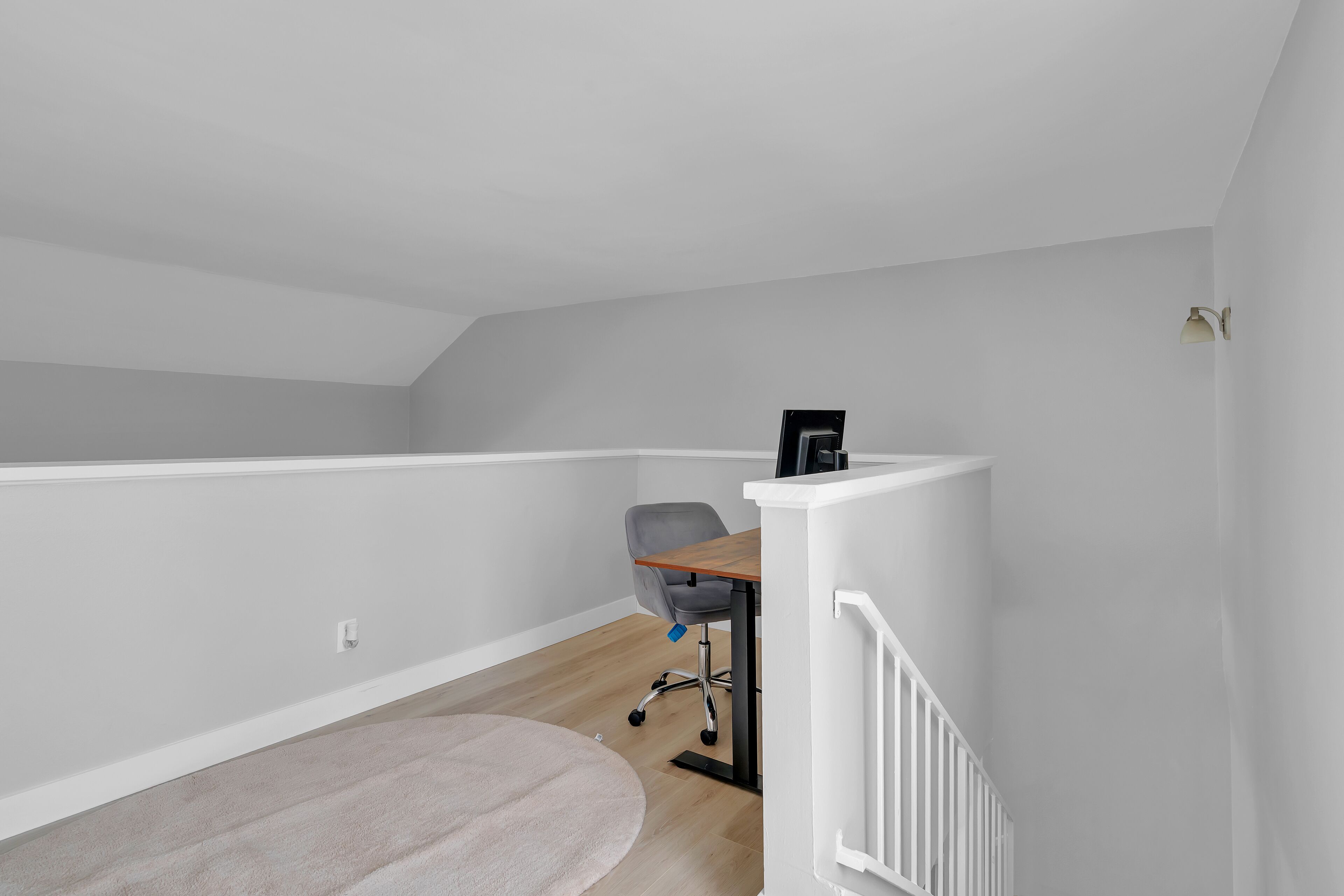 Una habitación con escritorio, silla y escalera.