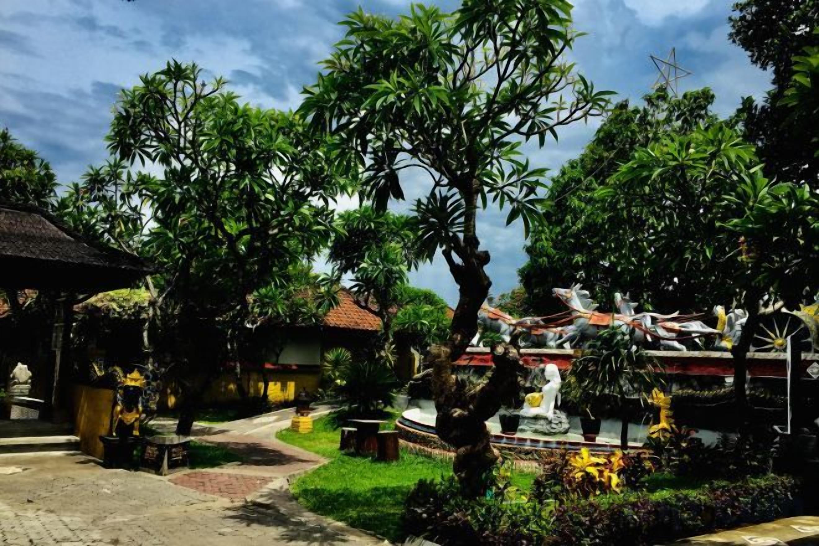 Un patio con un sendero, una estatua y arquitectura tradicional.