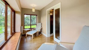A room with a wooden floor, a window with blinds, a chair, and a bed. - 4 bedroom accommodation in Compton Martin, near Cheddar (Compton Martin, near Cheddar)