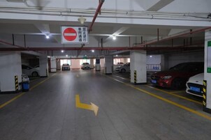 A multi-level parking garage with clear directional signage, multiple parking levels, and a yellow arrow indicating the direction to proceed.