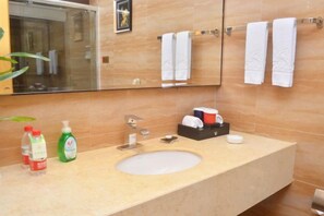 A bathroom with a sink, mirror, and towel rack. - Gold Deer Hotel (Nan'an)