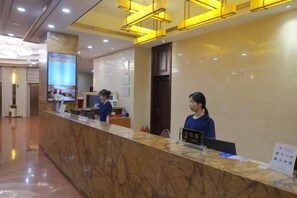 A hotel reception area with a marble counter, a digital screen displaying information, and a sign with the hotel's name. - Gold Deer Hotel (Nan'an)