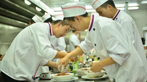 Chefs in white uniforms preparing food in a kitchen. - Gold Deer Hotel (Nan'an)