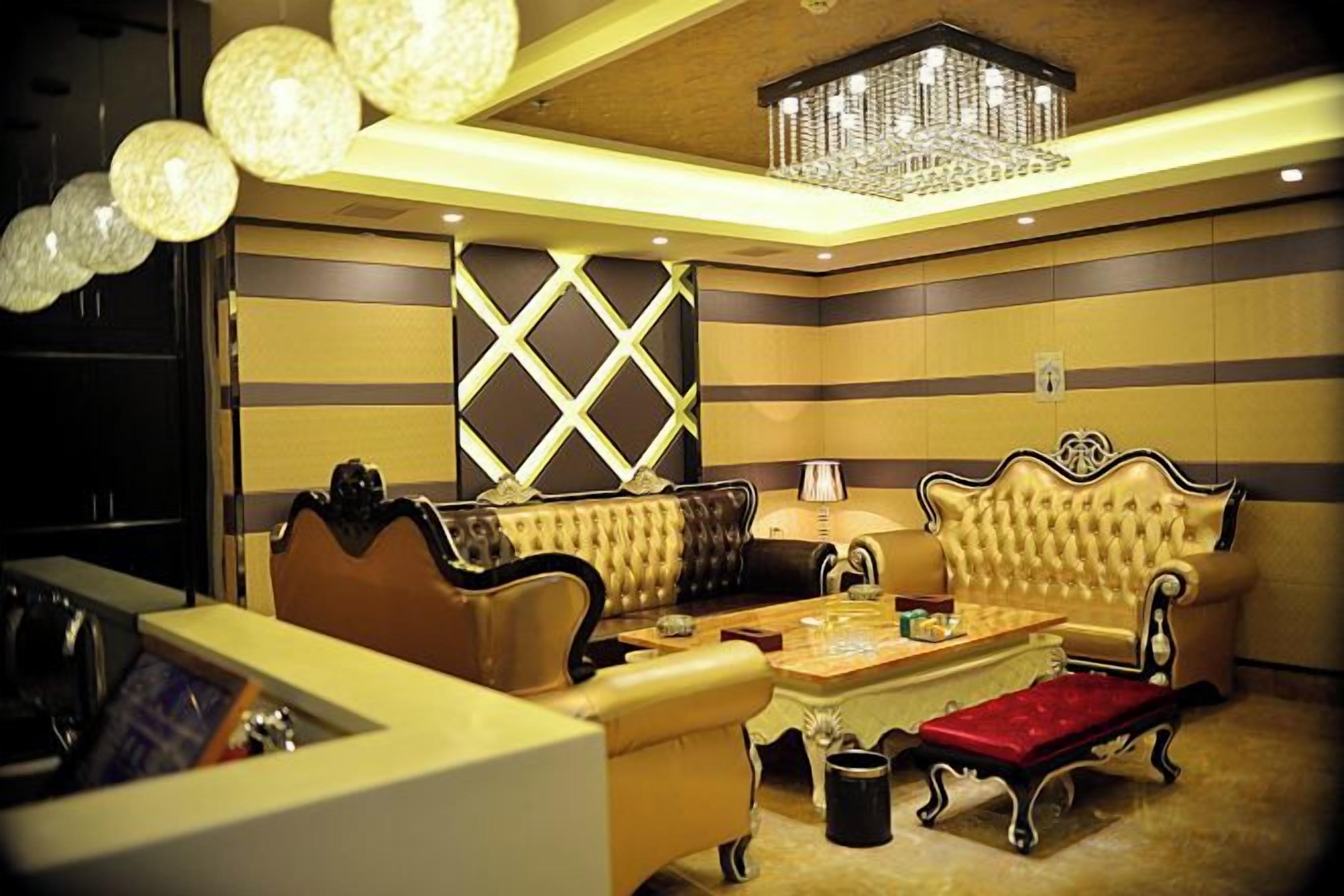 A room with a sofa set, a coffee table, and a chandelier.