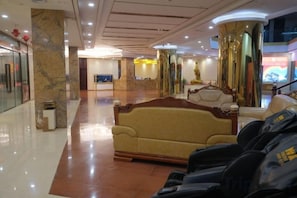A lobby with a reception desk, a sofa, and a seating area. - Gold Deer Hotel (Nan'an)