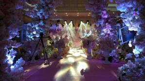 An indoor venue with a floral archway and a central stage. - Gold Deer Hotel (Nan'an)