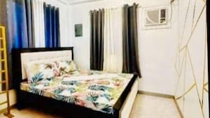 A bedroom with a bed, curtains, a ladder, and a window. - RedDoorz Plus @ Remarkable Hotel Alcala Pangasinan (Pangasinan)
