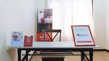 A table with a RedDoorz sign, a RedDoorz brochure, and a RedDoorz poster.